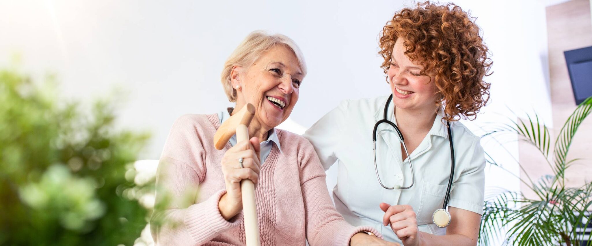 senior sitting with a healthcare worker at an assisted living community