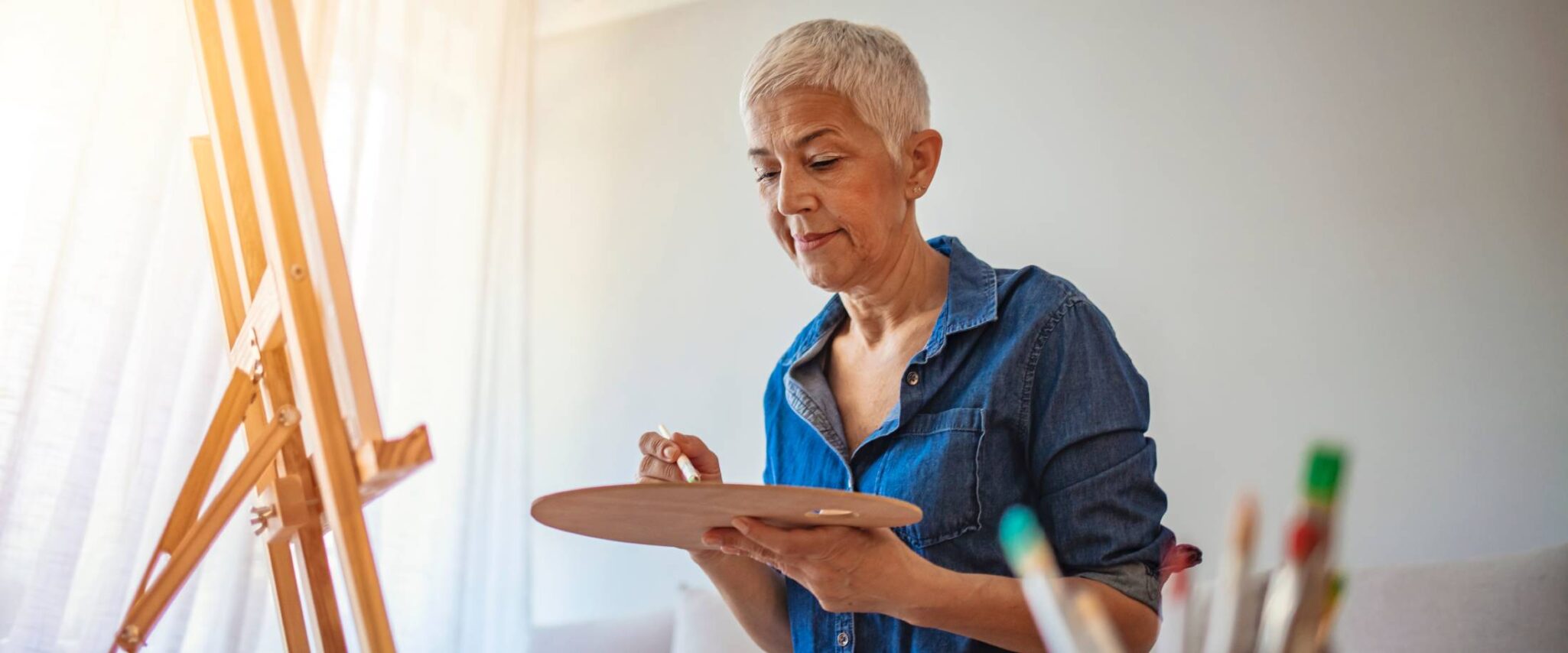 senior lady painting on a canvas for a summer craft