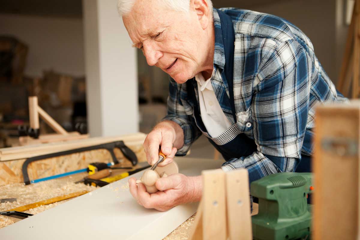 Senior man carving out a wood project