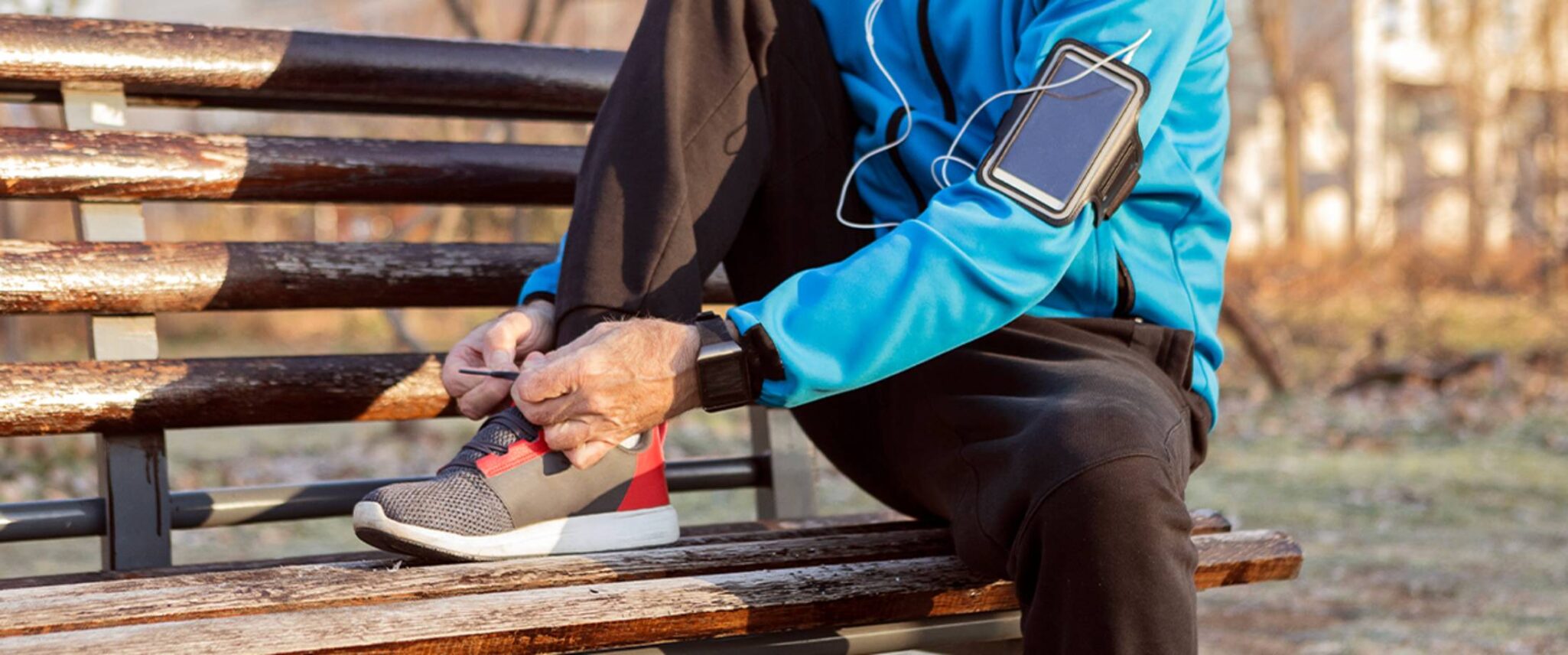 senior taking a quick stop to tie their shoe while on a jog