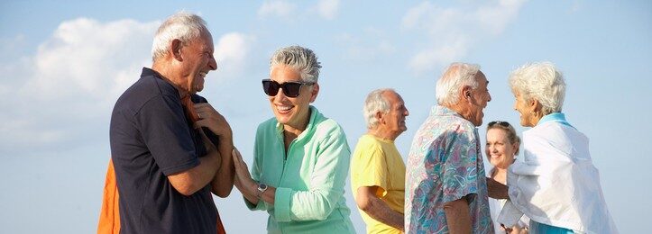 senior friends talking on the beach