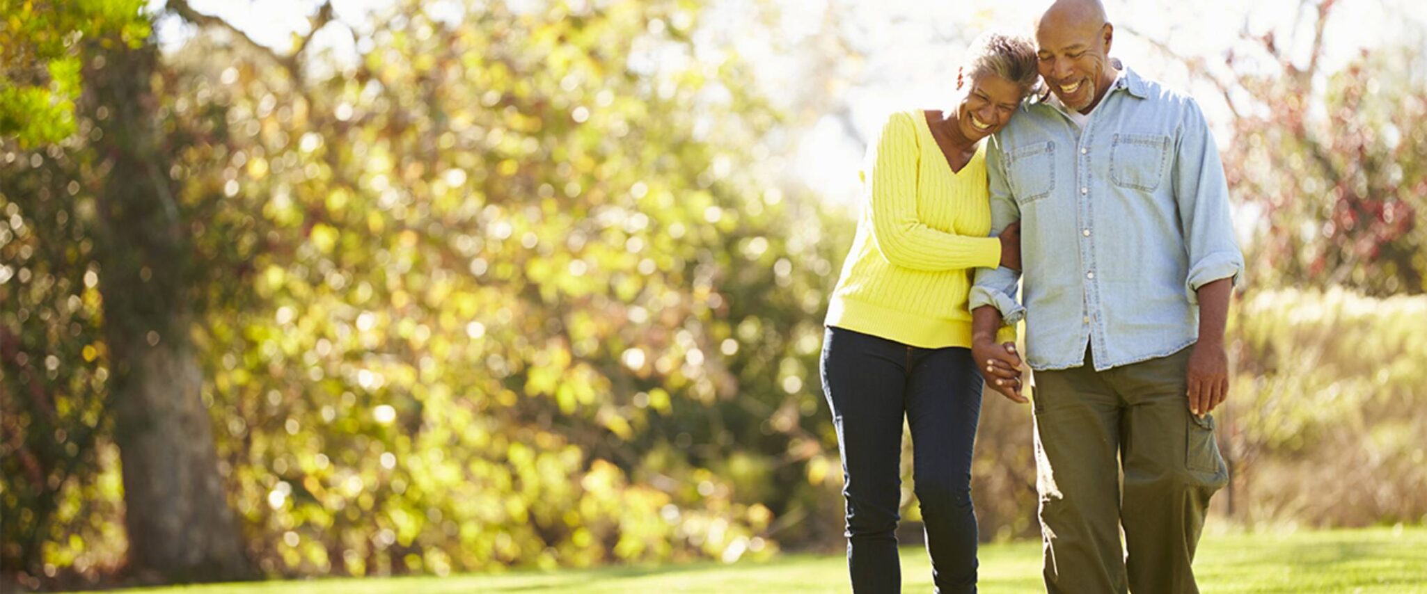 A senior couple go walking in the woods during the fall