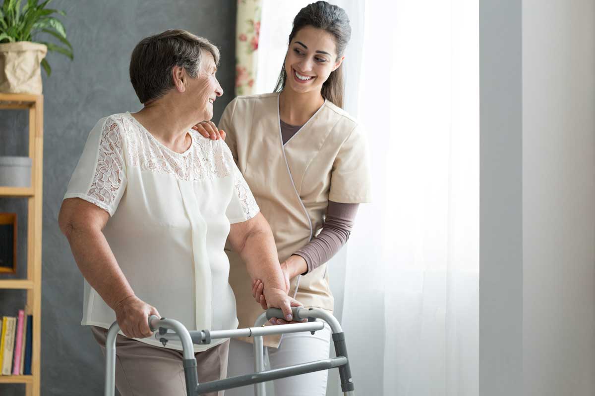 senior health professional helps woman with her walker